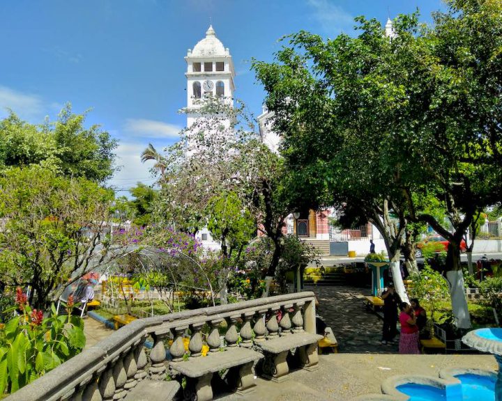 Die grüne Plaza Central in Juayúa auf der Ruta de las Flores mit der Iglesia Santa Lucia im Hintergrund.