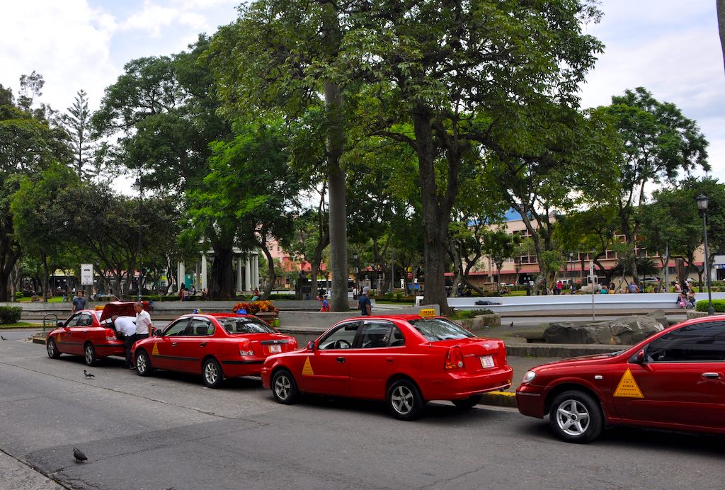 Rote Taxis warten am Parque Morazán auf Kundschaft in Costa Ricas Hauptstadt San José.